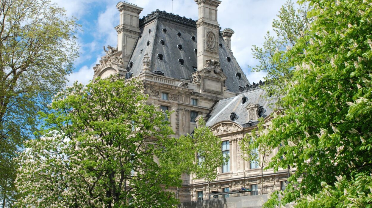 Palais historique entouré d'arbres en fleurs, ciel bleu.