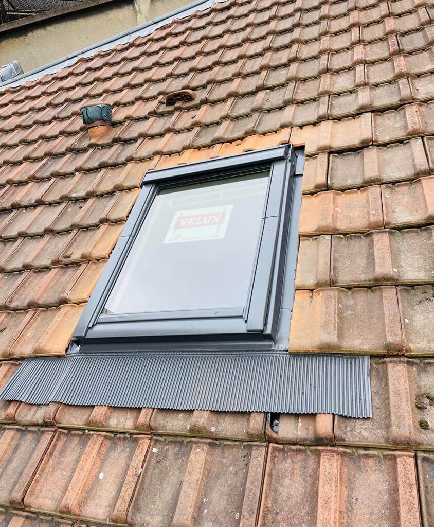 Fenêtre de toit Velux sur toiture en tuiles.