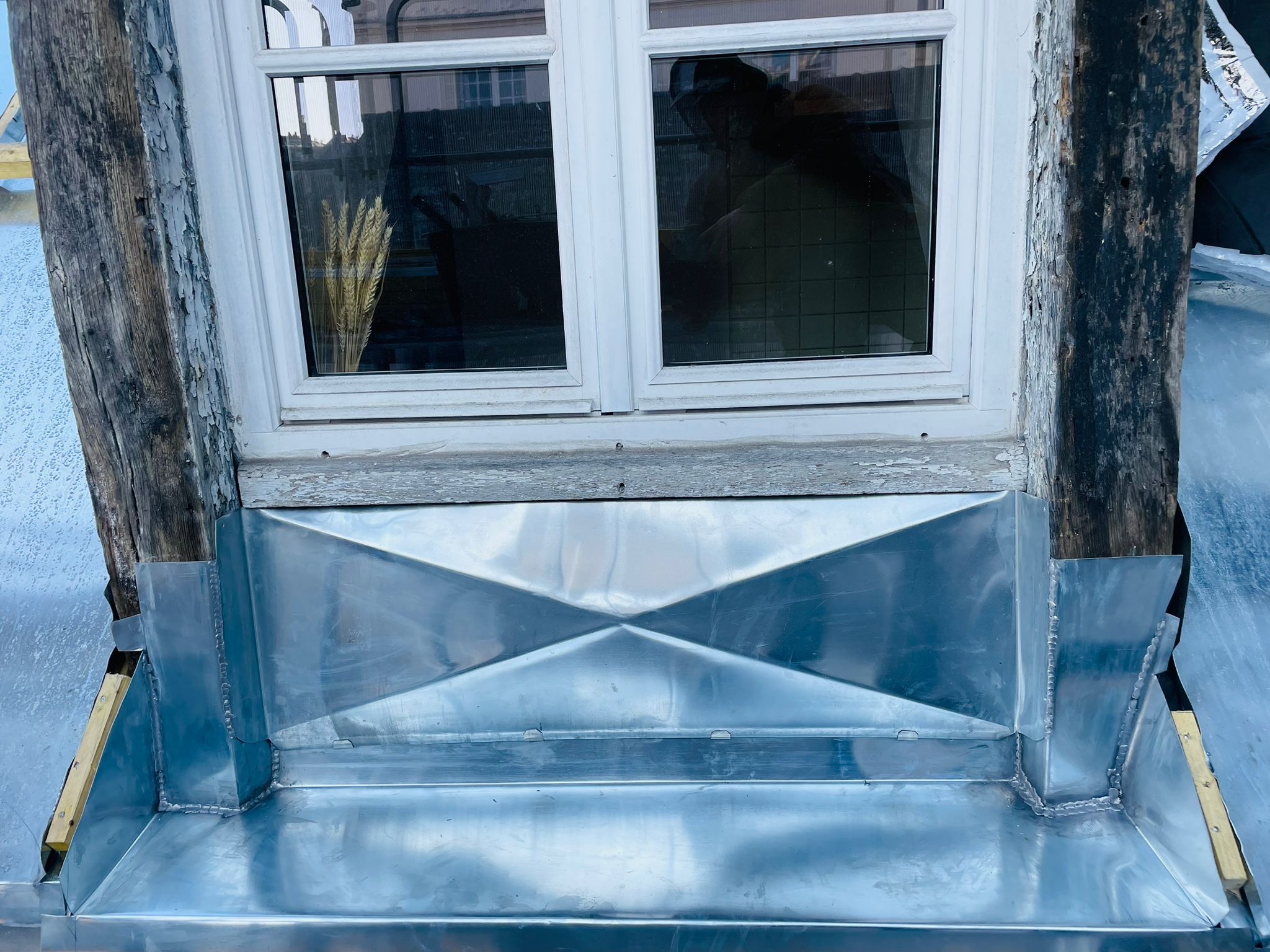 Zinc en façade, fenêtre boisée, style rustique.