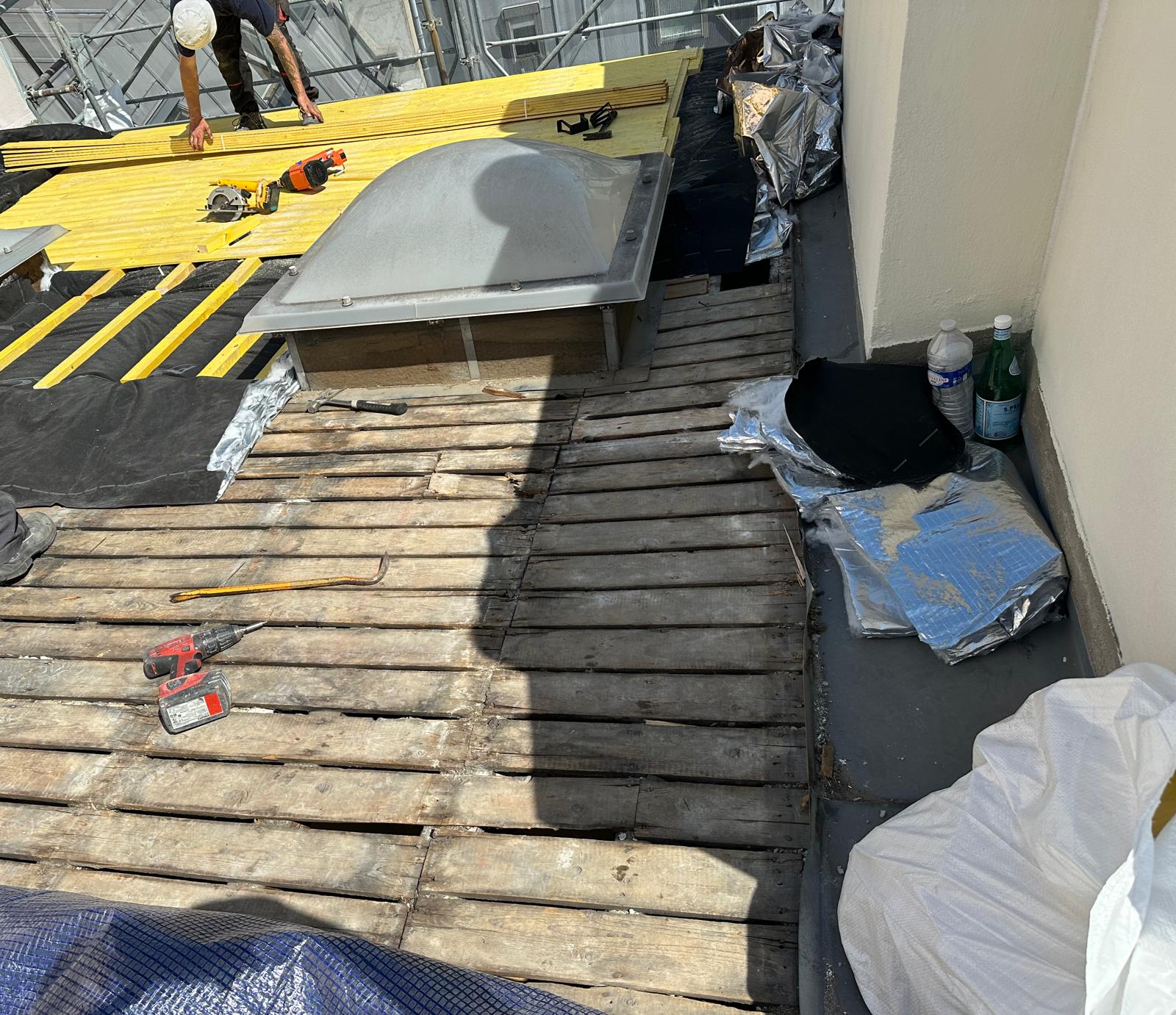 Travaux d'isolation toiture avec ouvriers et matériel.