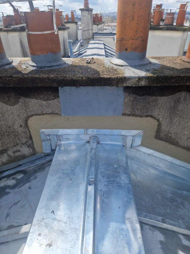 Réparation de toiture en métal sur bâtiment urbain.
