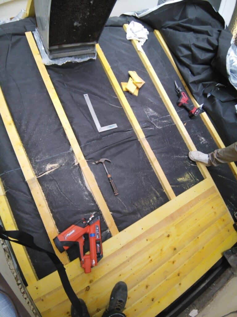 Travaux de toiture avec outils et matériaux visibles.
