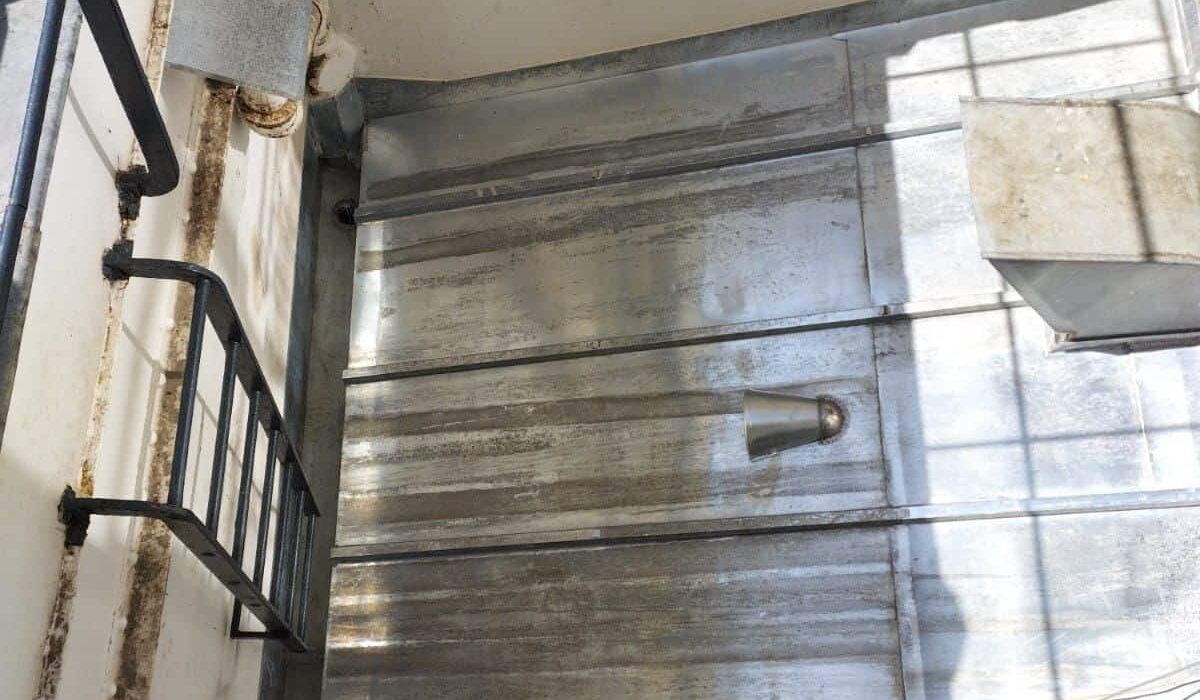 Cage d'escalier en métal éclairée par le soleil.