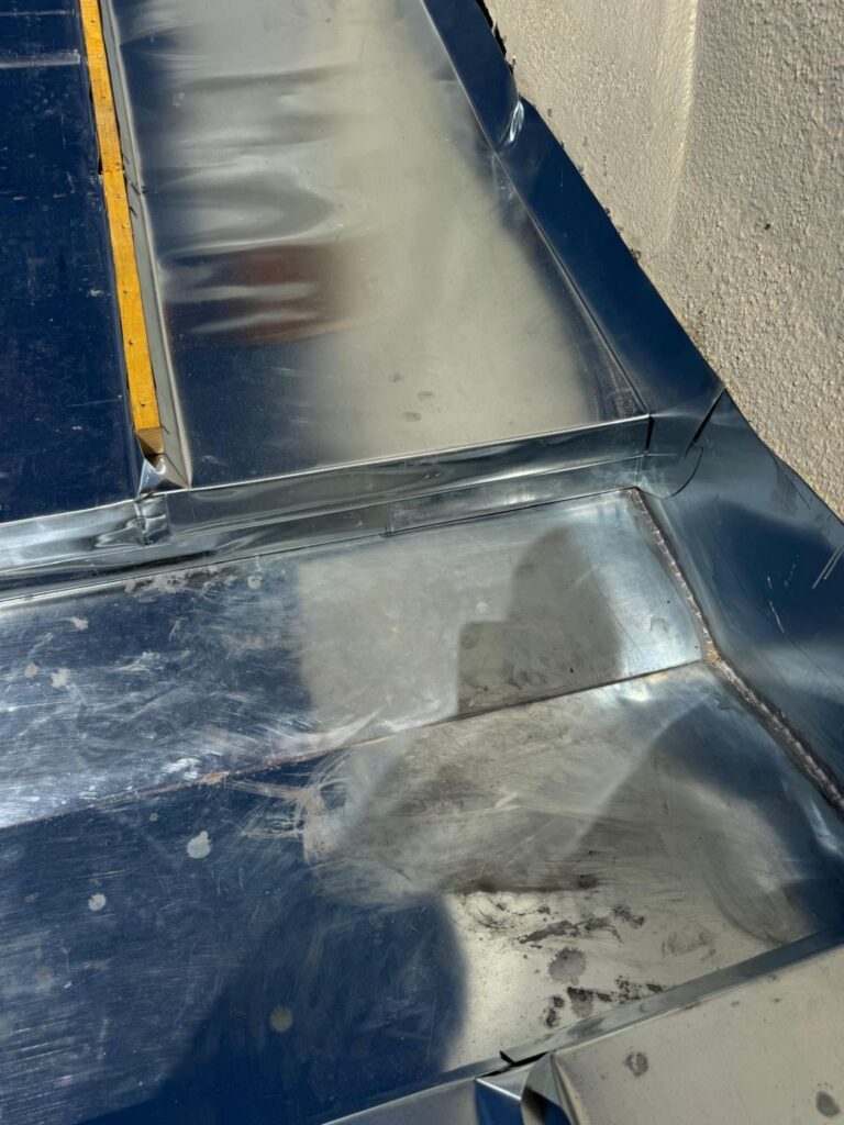 Raccord en zinc entre le chéneau et le mur après reprise de toiture à Paris