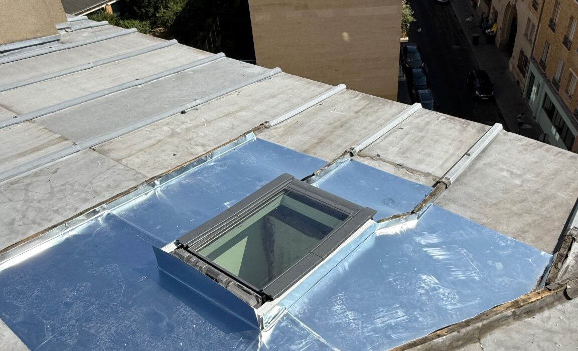 Fenêtre de toit Velux posée sur une couverture zinc à Paris, habillages façonnés sur place