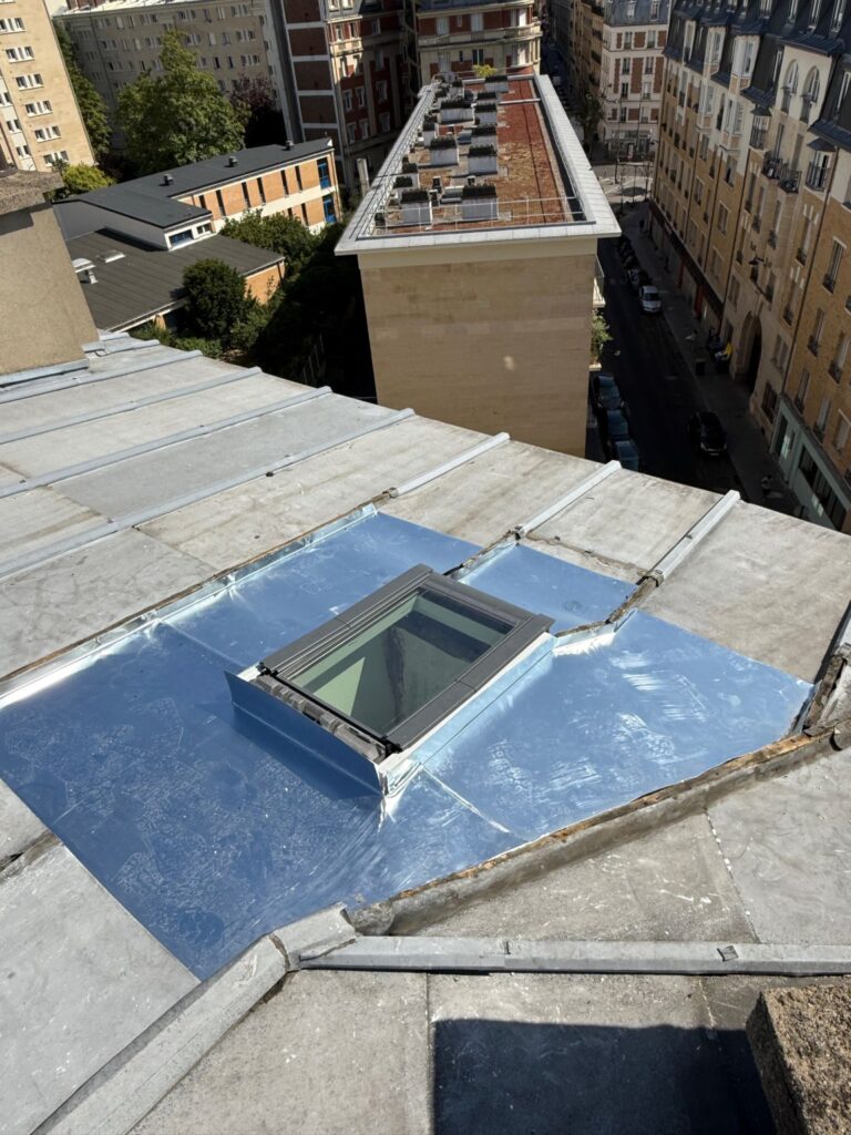 Fenêtre de toit Velux posée sur une couverture zinc à Paris, habillages façonnés sur place